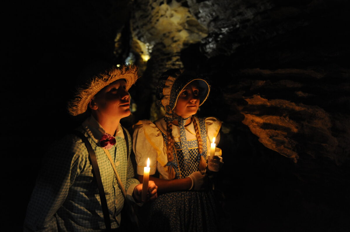 Several people posed for a photo inside a cave.