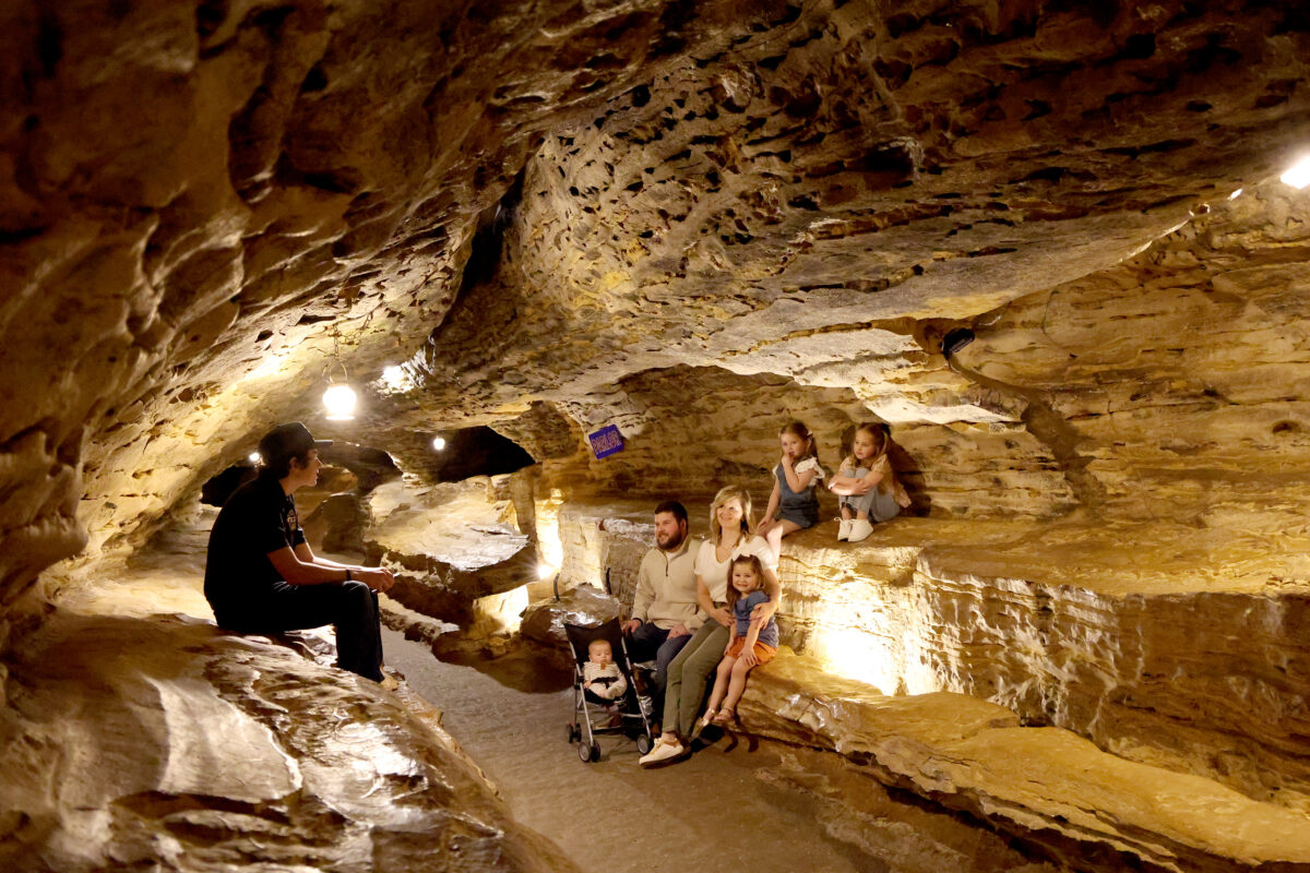 Several people posed for a photo inside a cave.