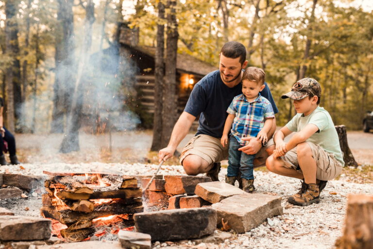 A family cooks around a campfire at Silver Dollar City Campground.