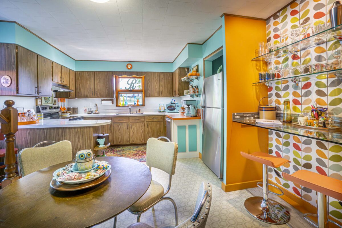 A kitchen with bright colors and a patterned decorative wall.