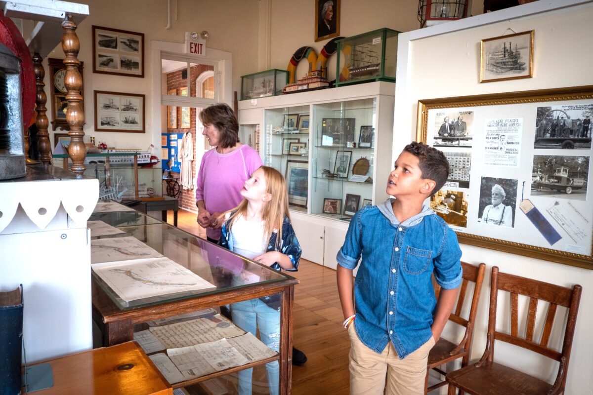 Three people peruse displays in a museum.