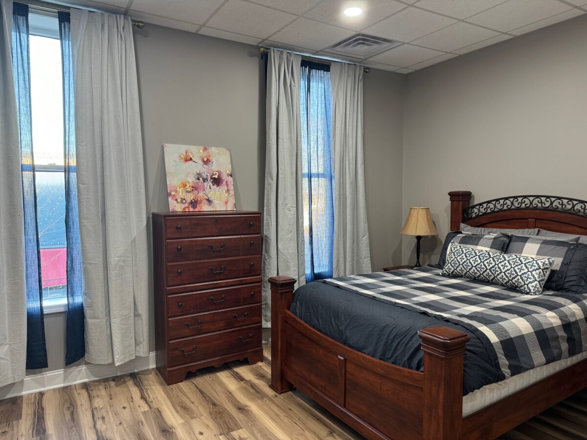 Bedroom, one queen size bed. Dresser with TV. Windows overlook Main Street and the river.