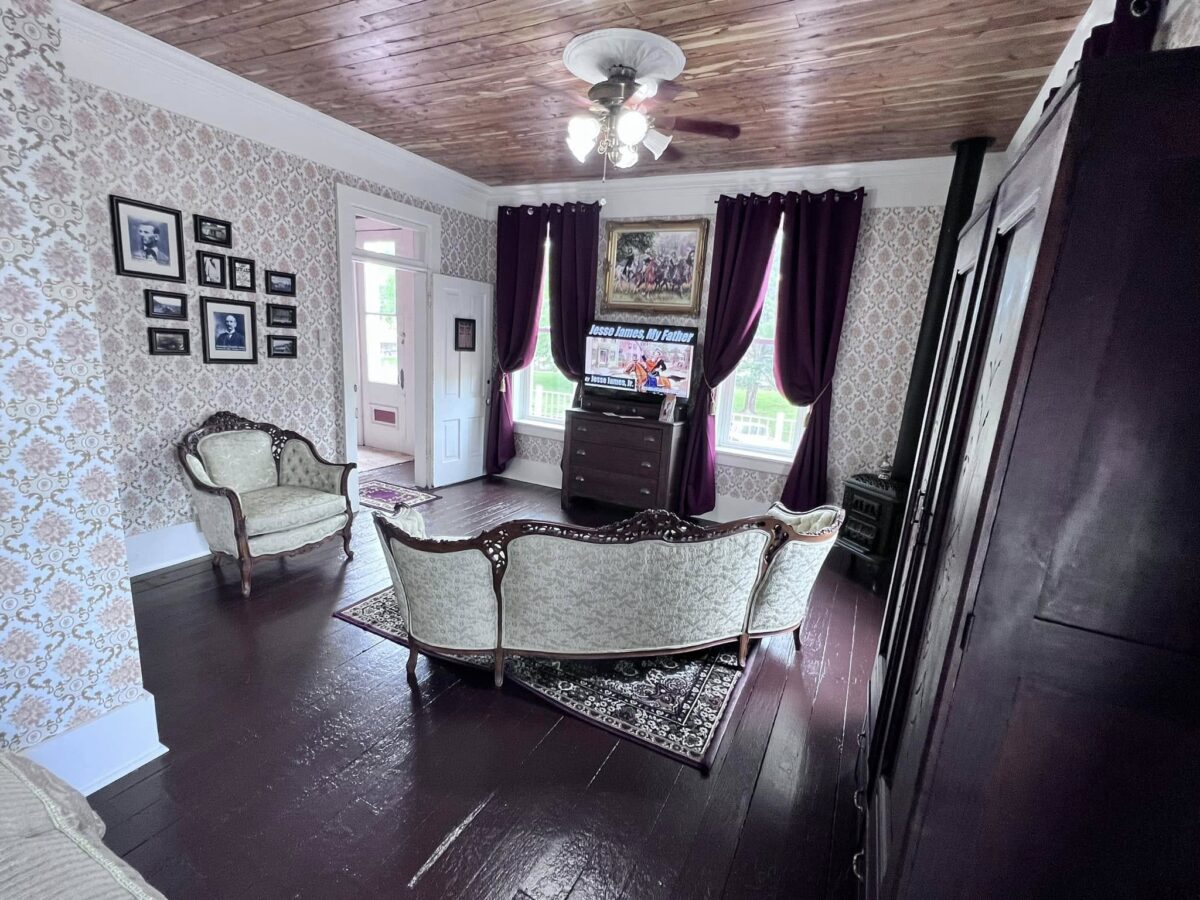 The interior of a brown and white room with a white chair and love seat.
