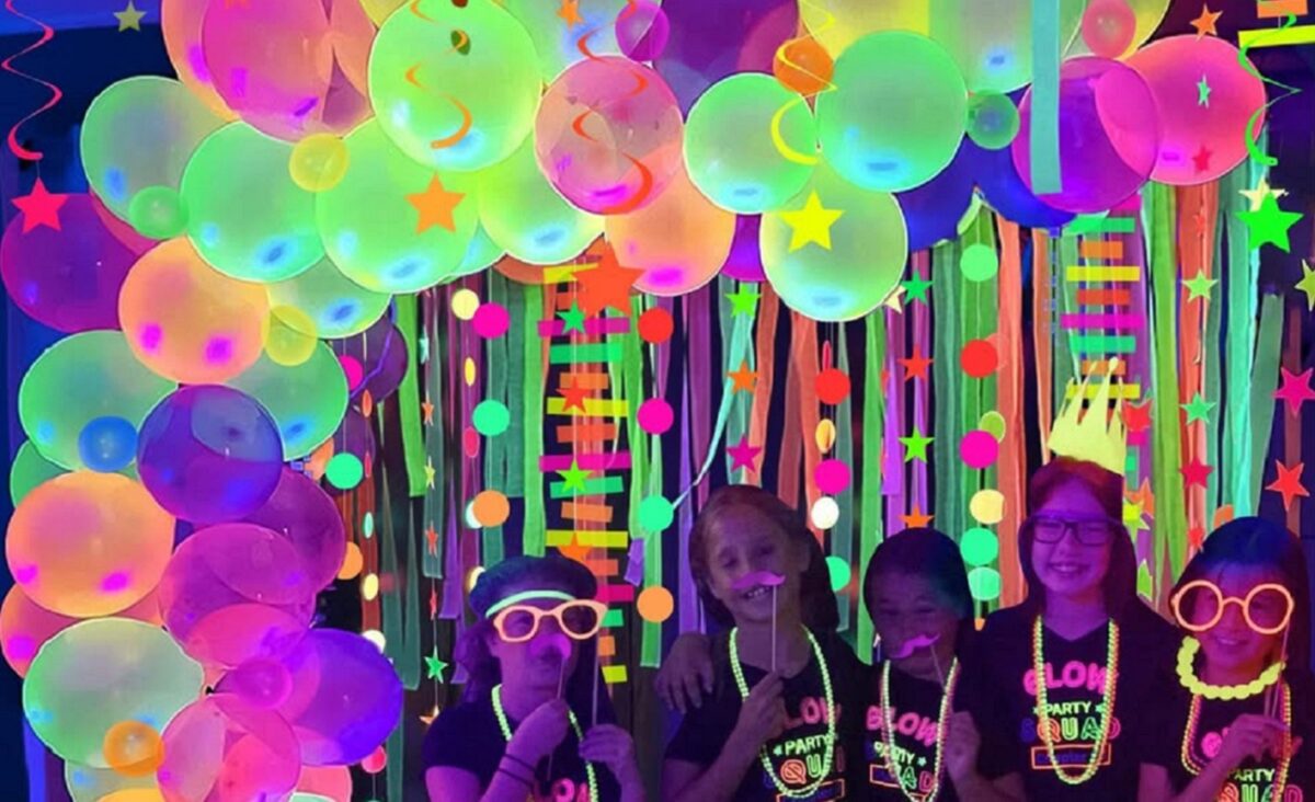 Children pose during a neon party.