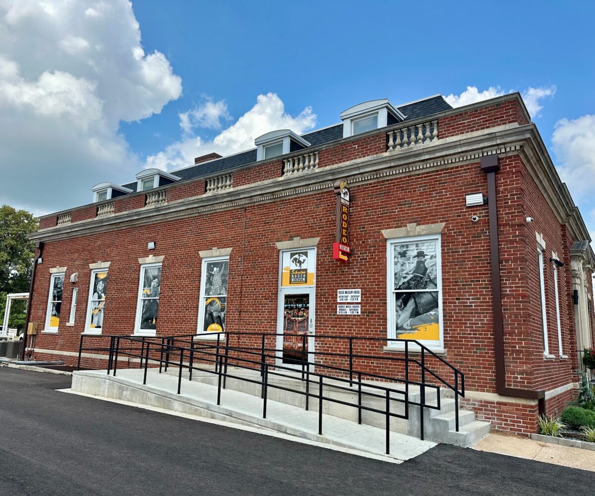The exterior of a brick building with steps and a railing.