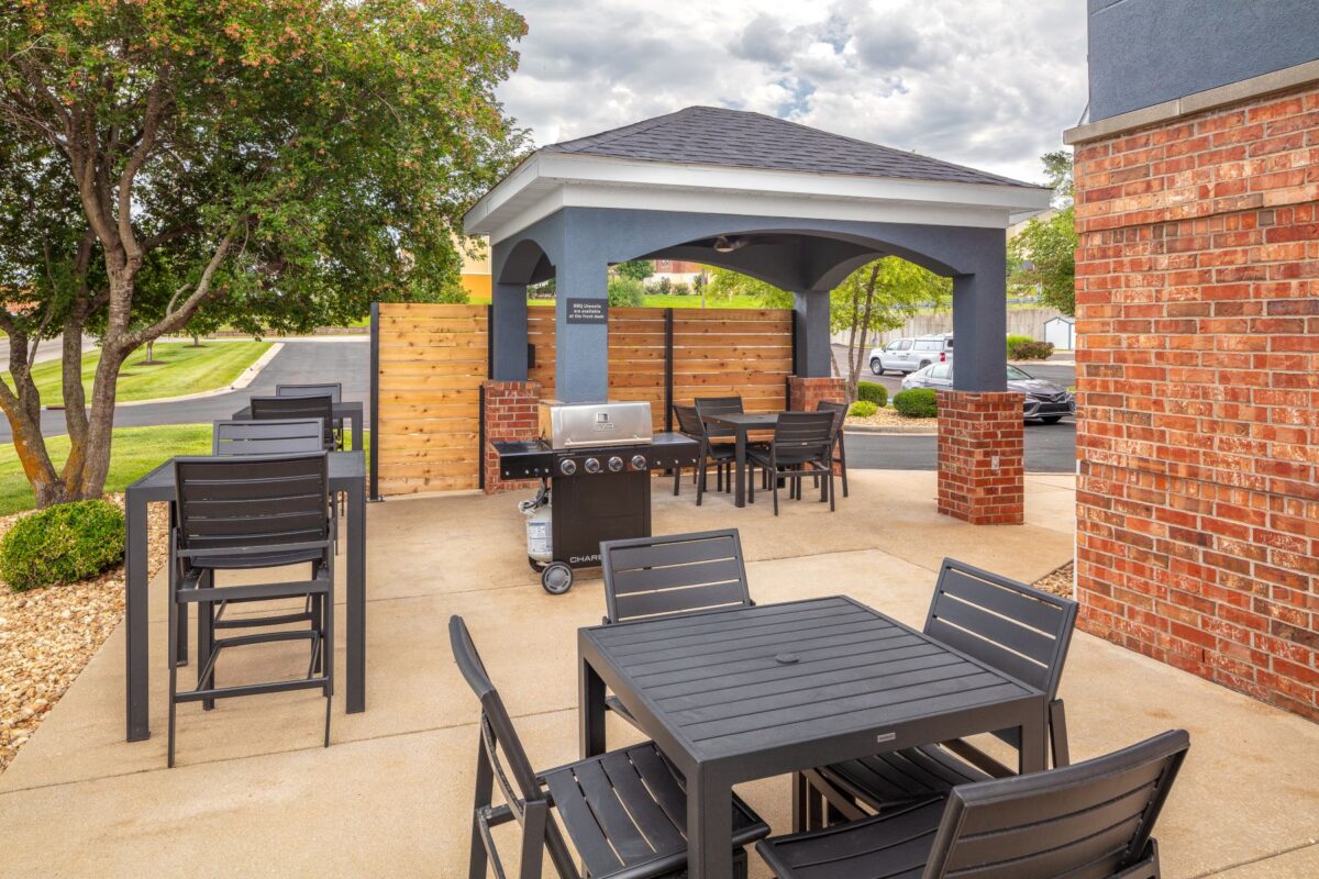 Outdoor covered gazebo grill area with seating.