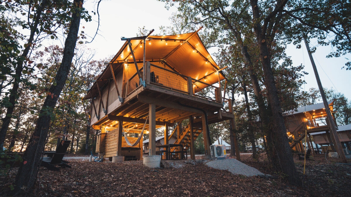 Large Yurt tent set on platform above patio with lights strung on top.