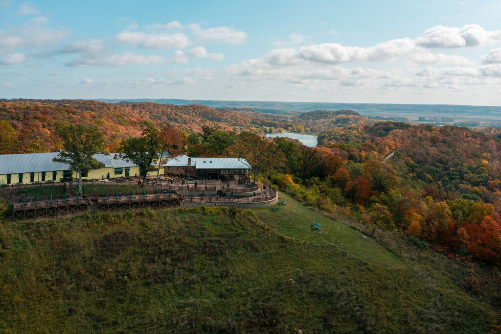 Aerial view of winery in fall with rolling hills in background.