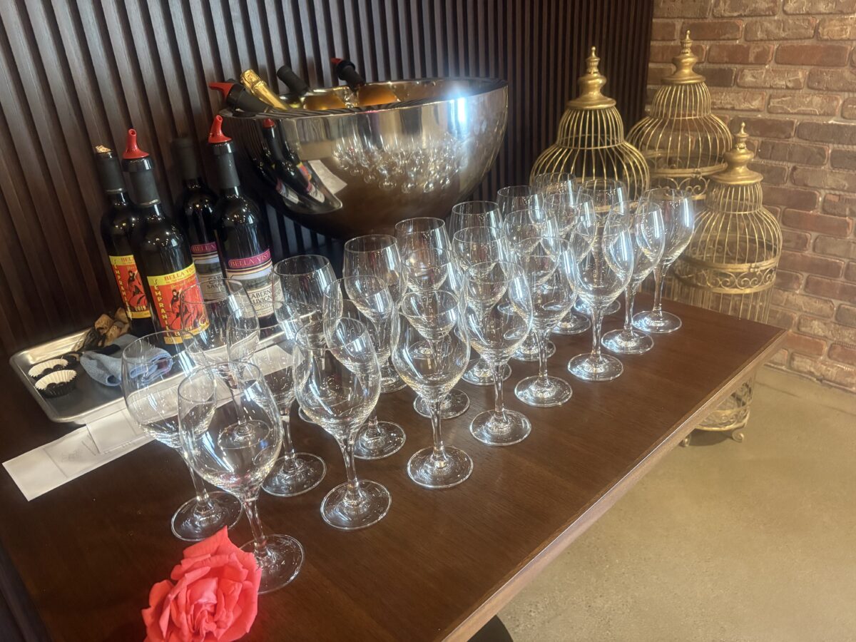 Wine glasses and bottles line a table.