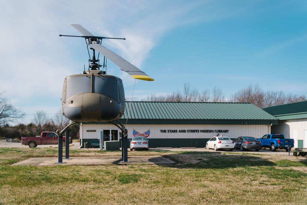A green helicopter sits stationary outside of The Stars and Stripes Museum/Library in Bloomfield, Missouri.