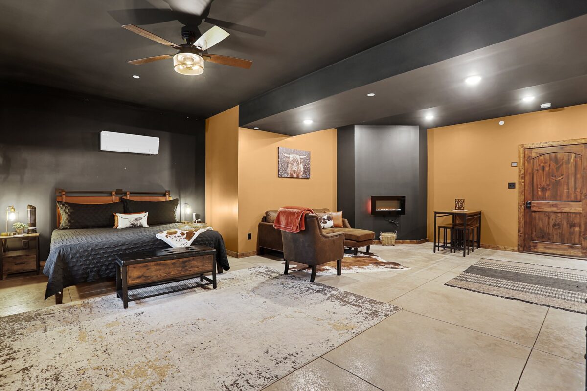 A rustic interior room with wood floors and tables and seating.