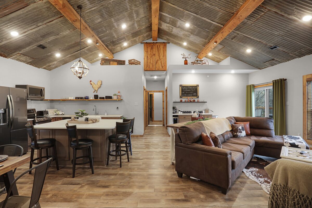 A rustic interior room with wood floors and tables and seating.