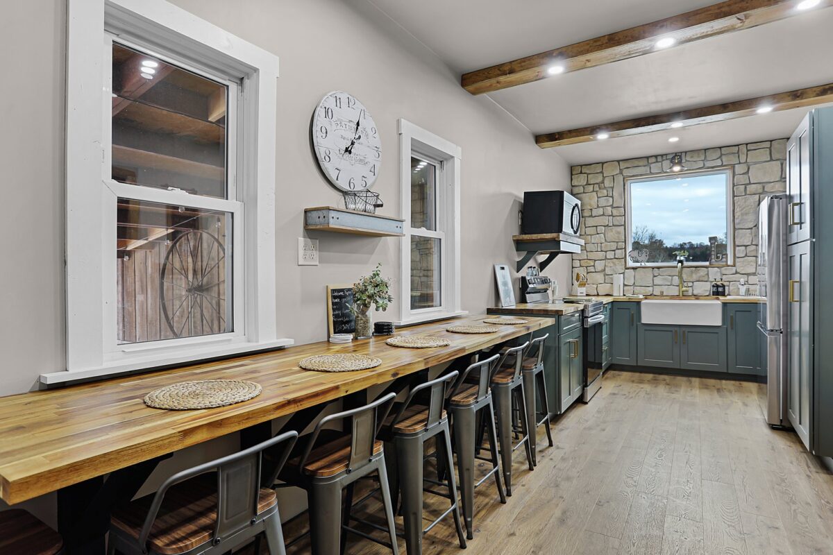 A rustic interior room with wood floors and tables and seating.