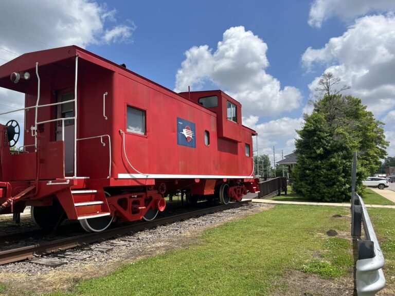A bright red caboose photographed in the day light.