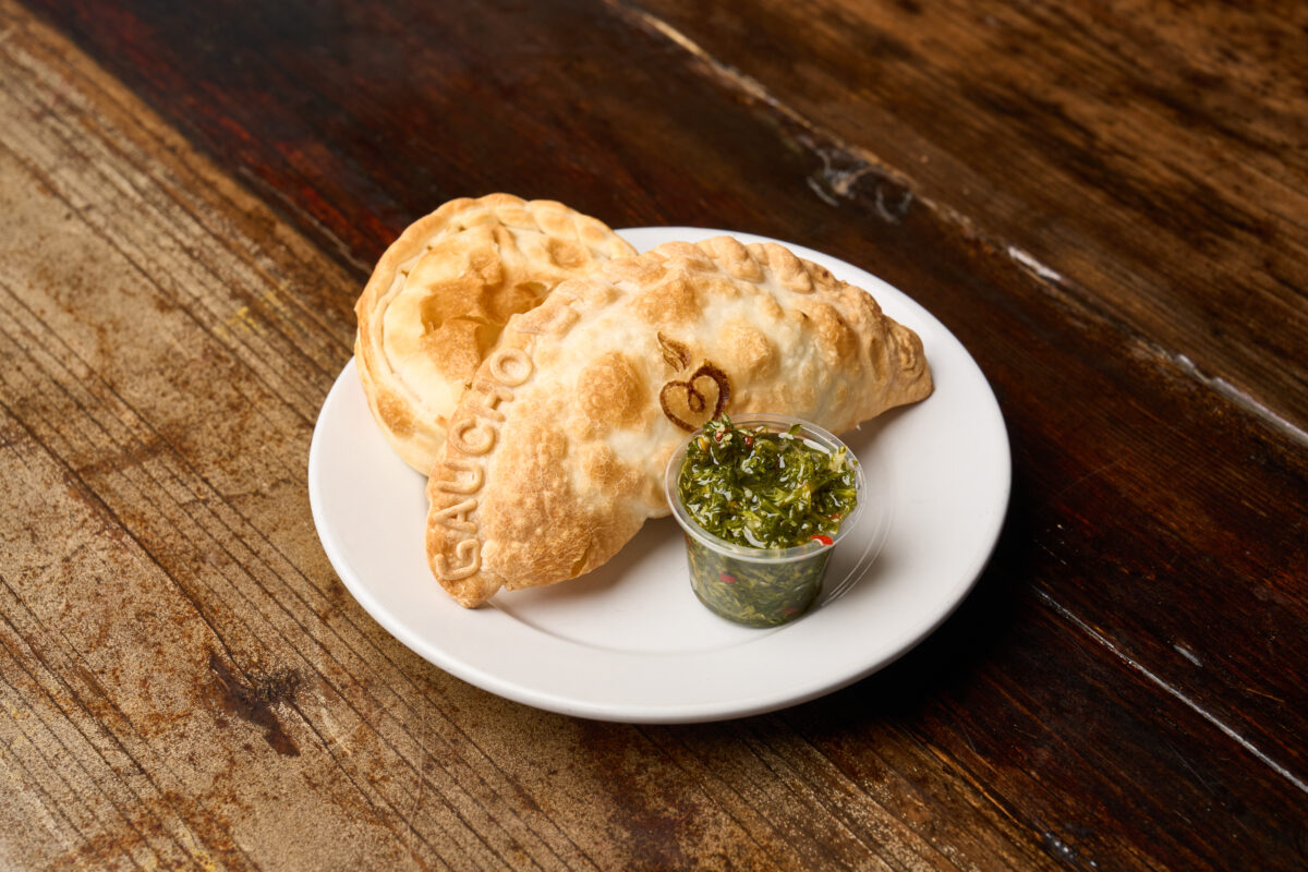 A beef empanada with sauce.