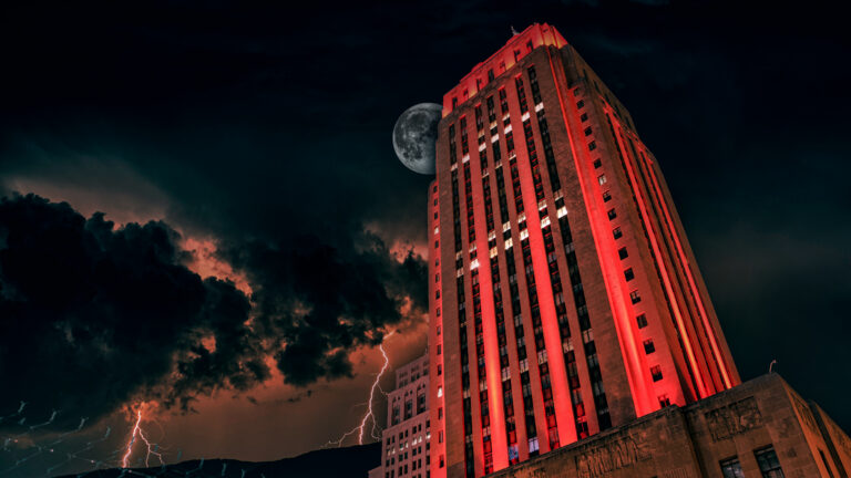 The Kansas City Courthouse looms red and menacing over the city at night.