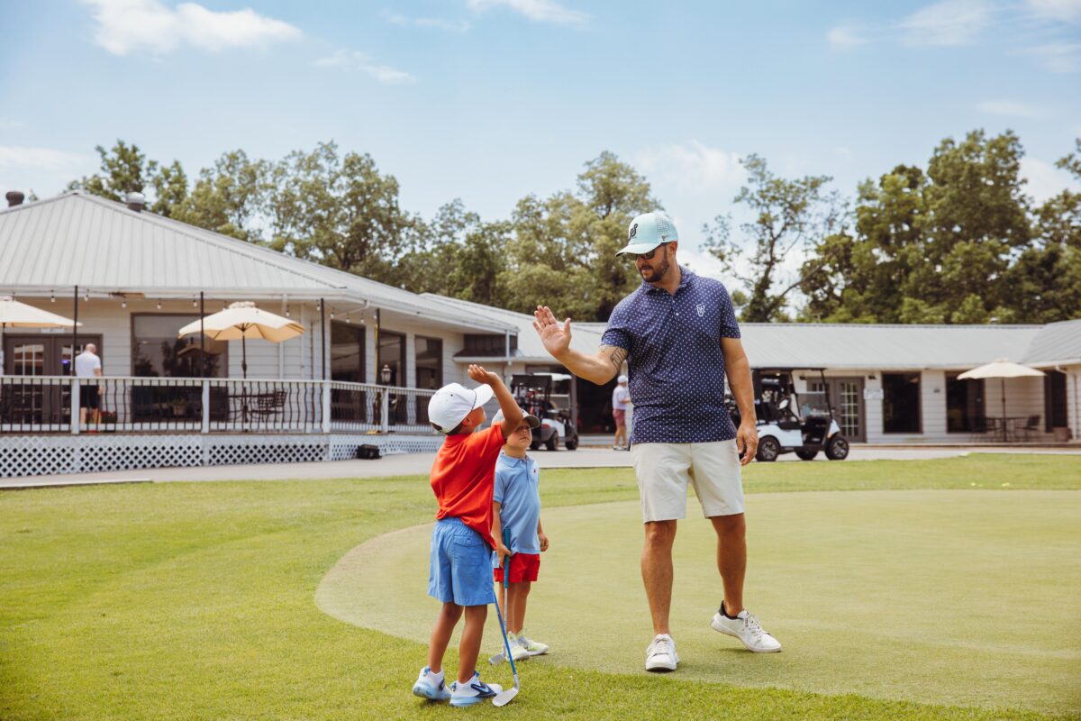 Golfers hi-five on the greens at Hidden Trails Country Club.