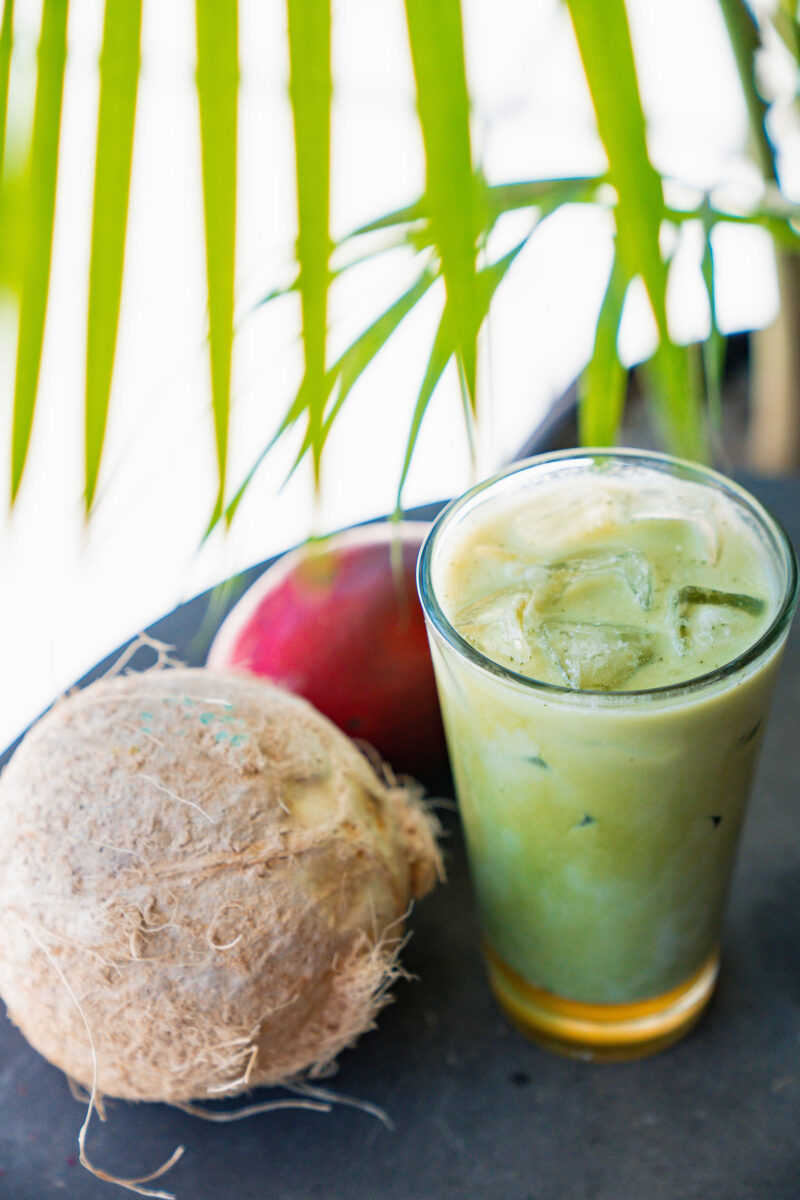 A matcha drink flanked by fruits.