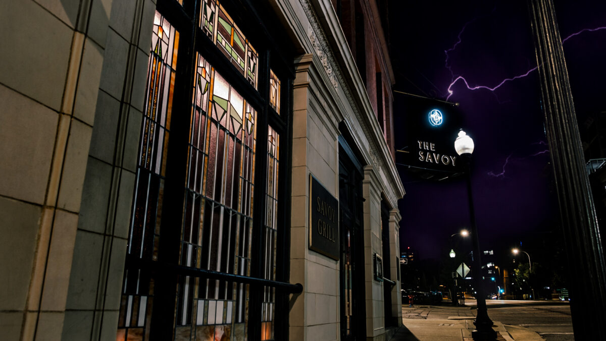 The exterior of the Savoy Hotel, gated and closed at night.