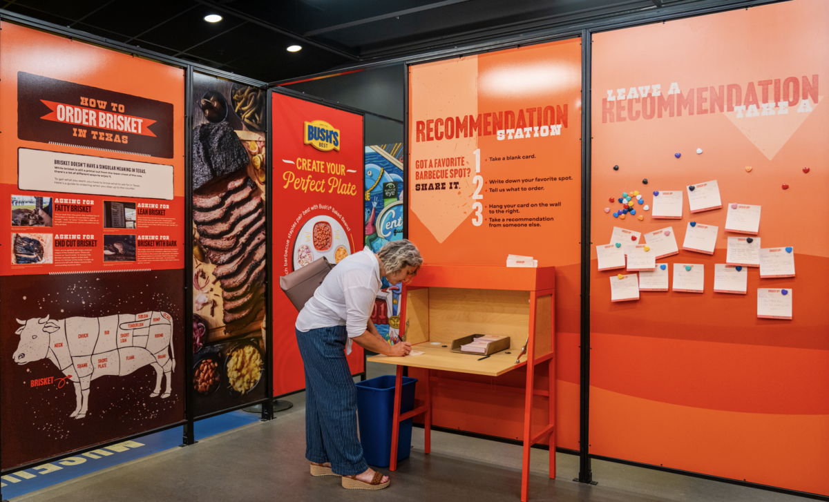 A woman writes down a recommendation for a barbecue restaurant in the Texas room at the Museum of BBQ.