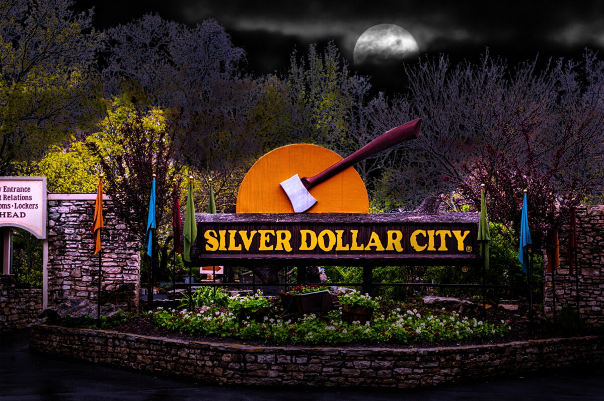 The Silver Dollar City logo with sunset and axe at night in the park.