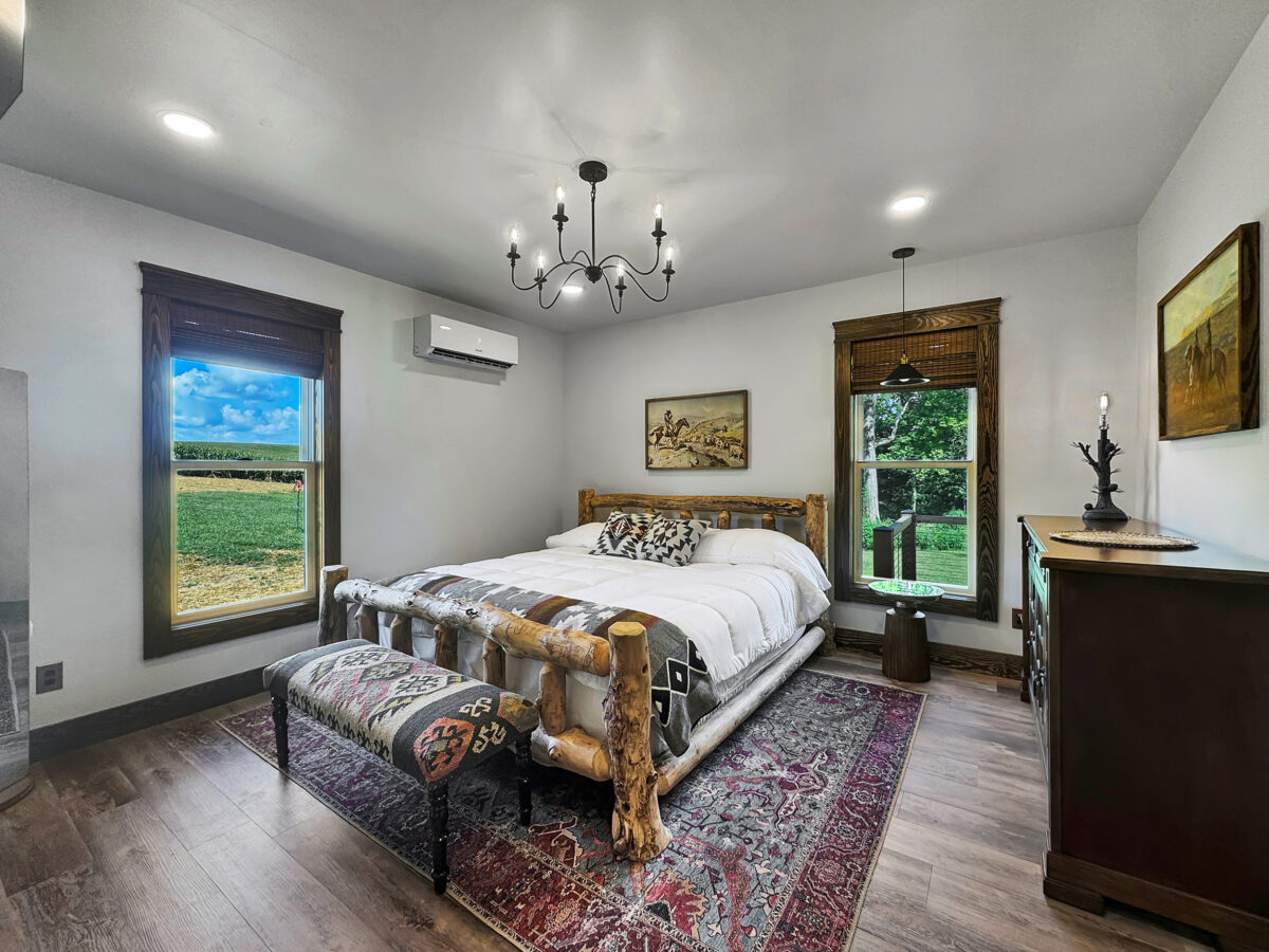 king-size-bed-two-windows-red-blue-rug