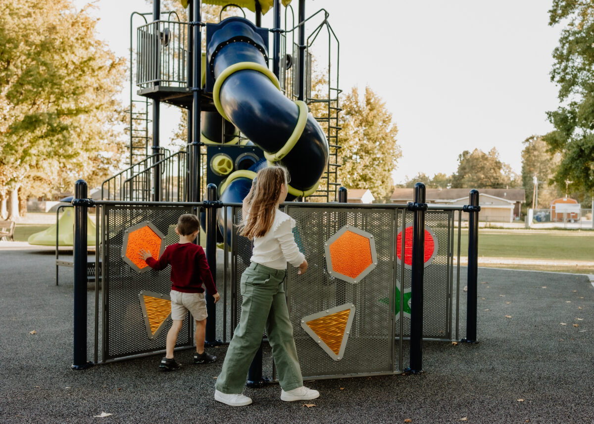 A family plays on equipment at a park.