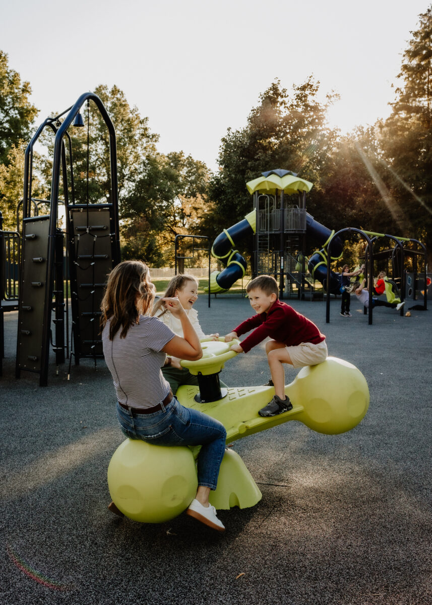 A family plays on equipment at a park.