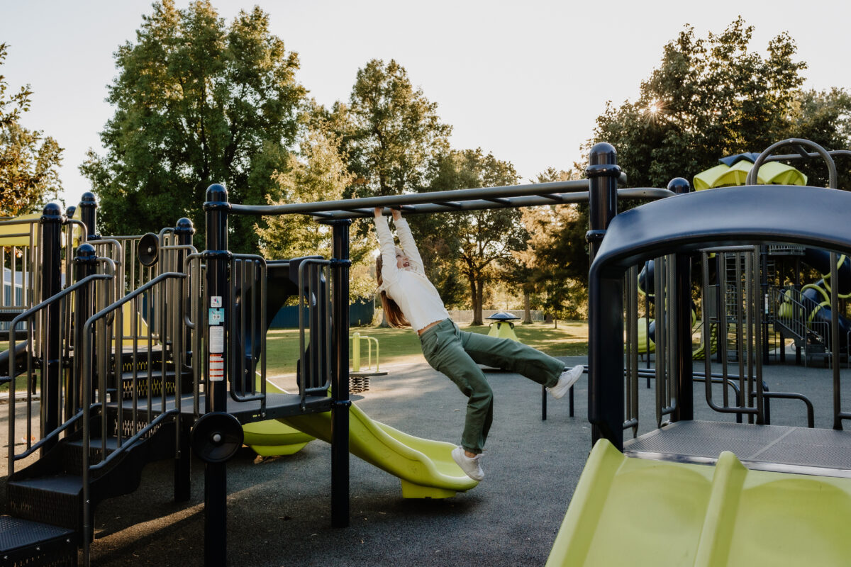 A family plays on equipment at a park.