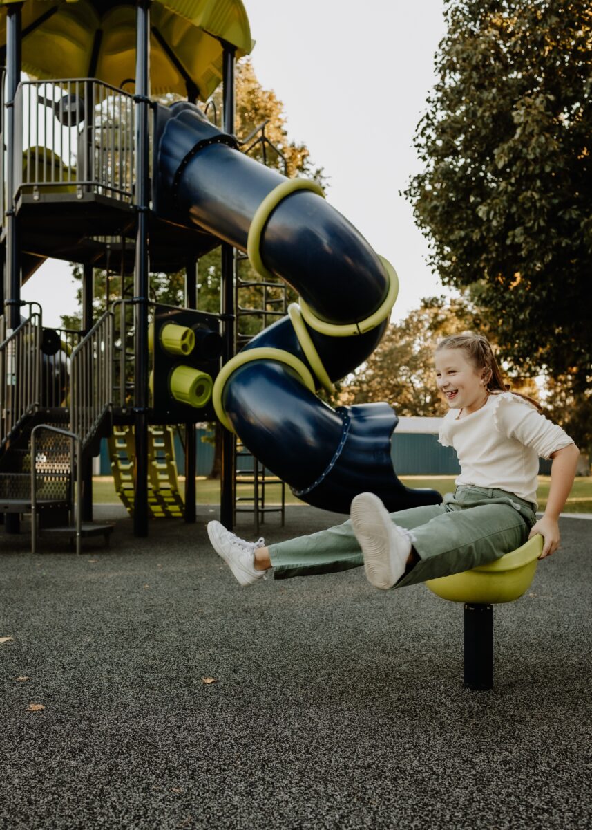 A child plays on equipment at a park.
