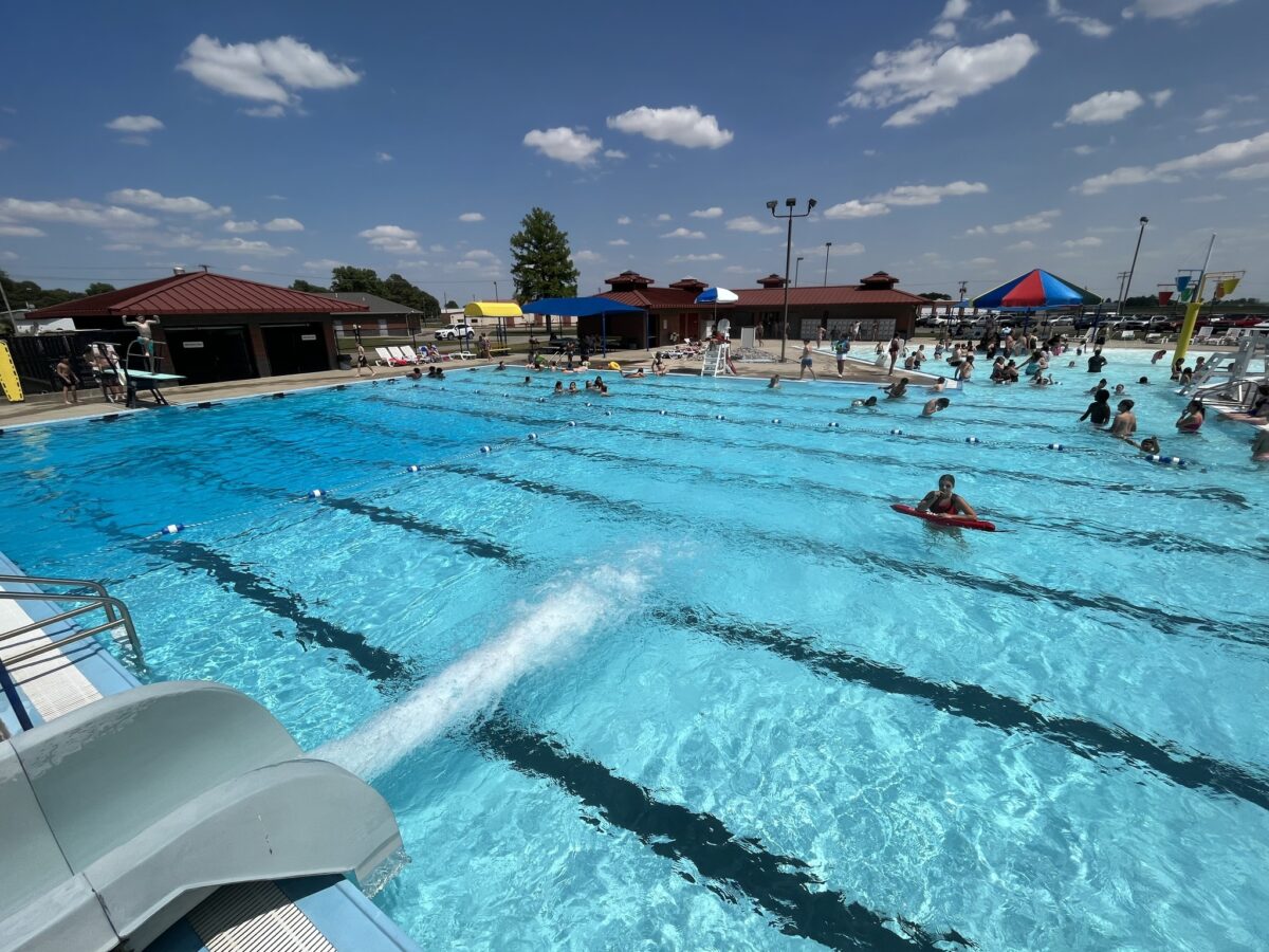 People in a busy pool on a bright day.