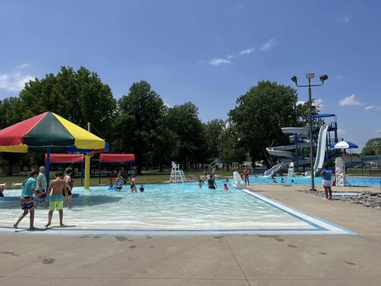 People in and around a busy pool.