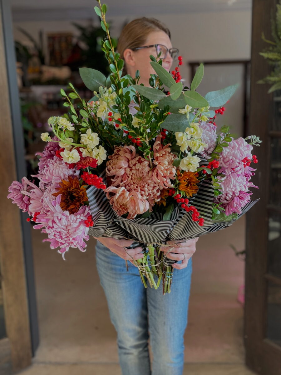 A woman holds a colorful bouquet.