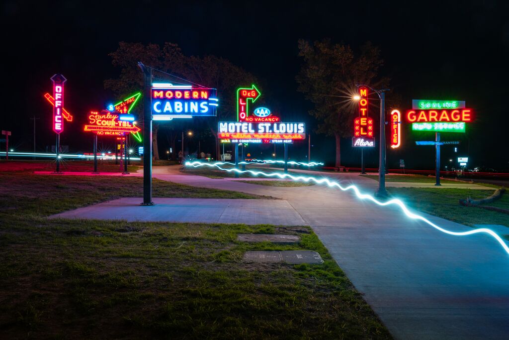 Neon signs light up the sky in a roadside park