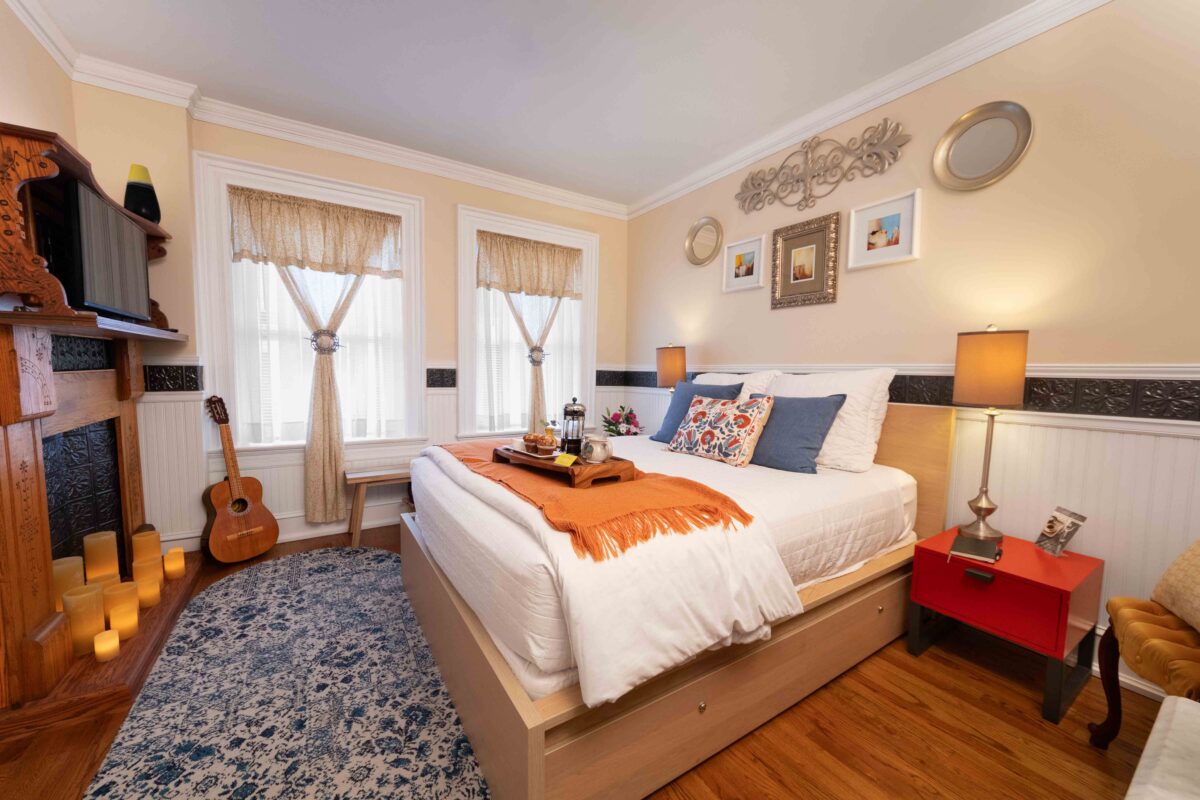 Romantic bed and breakfast room with a vintage fireplace and warm candlelight in Old Kate’s Room at Main Street Inn.