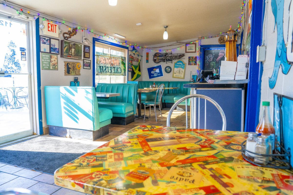 Dining room with bright teal booths and coastal decor at The Fish Market