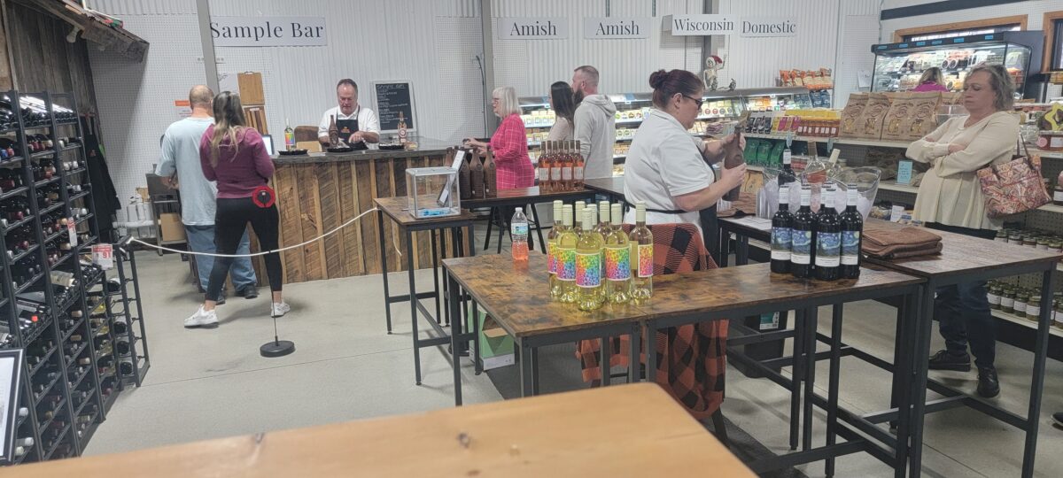 People sample food and drink at a cheese and wine pairing event.