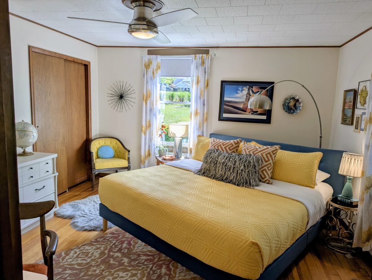A bedroom with yellow dressing and vintage furnishings.