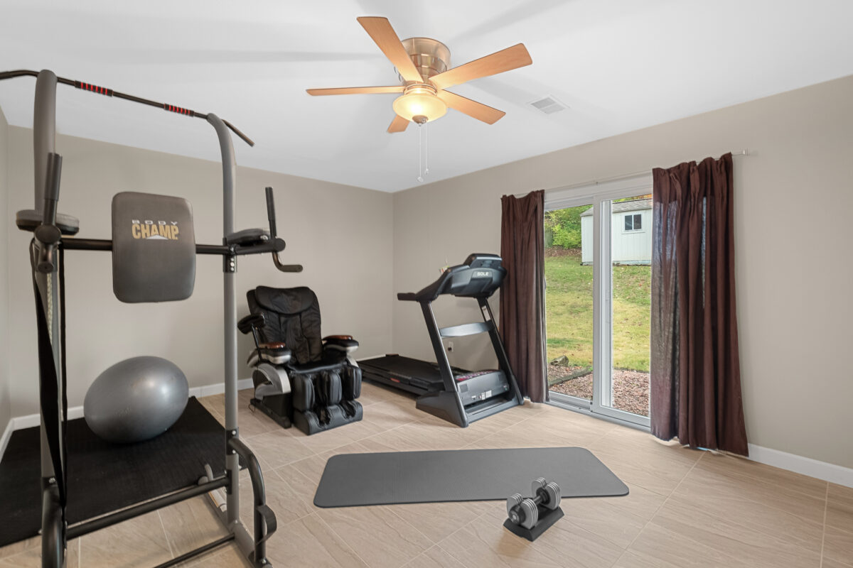A home gym with exercise equipment and a patio door.