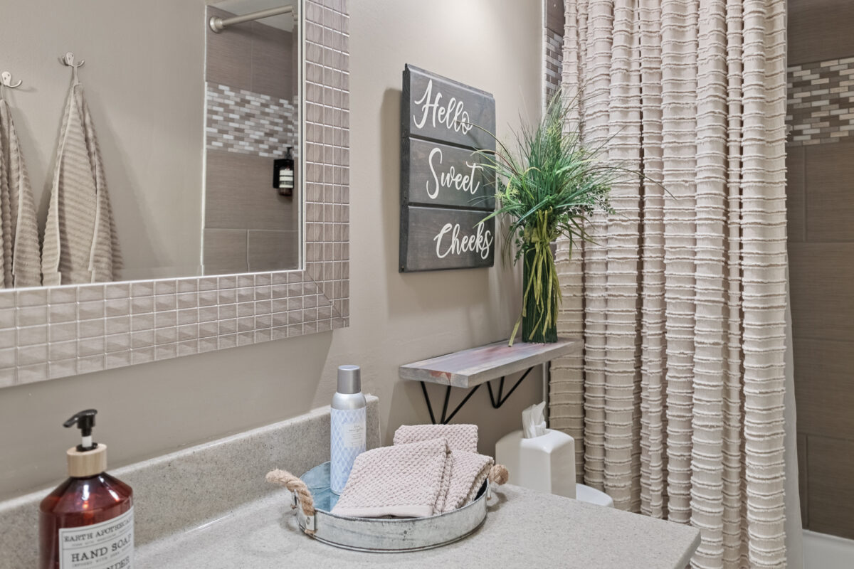 A bathroom decorated with signage and plants.