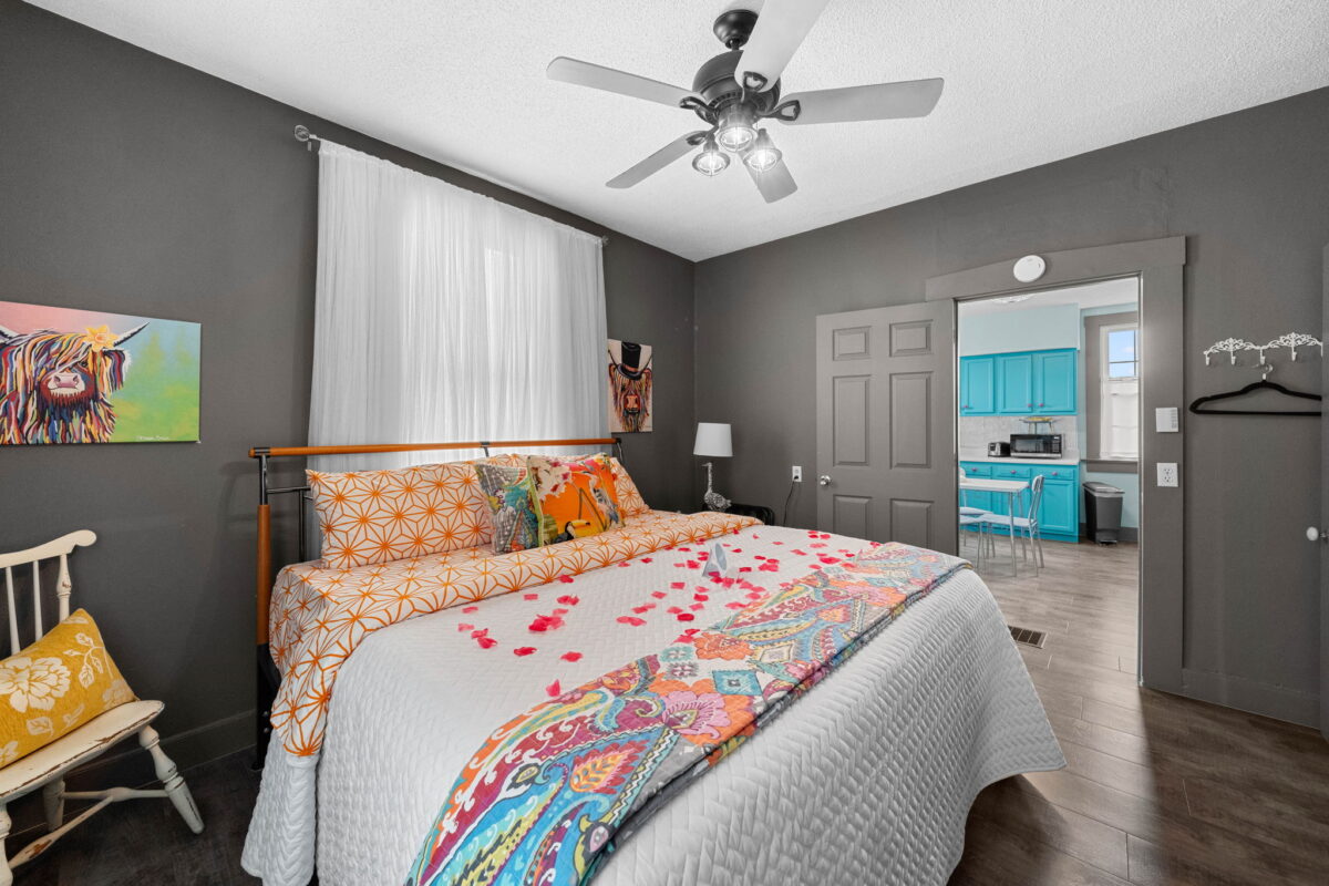 The interior of a bedroom with a large made bed.