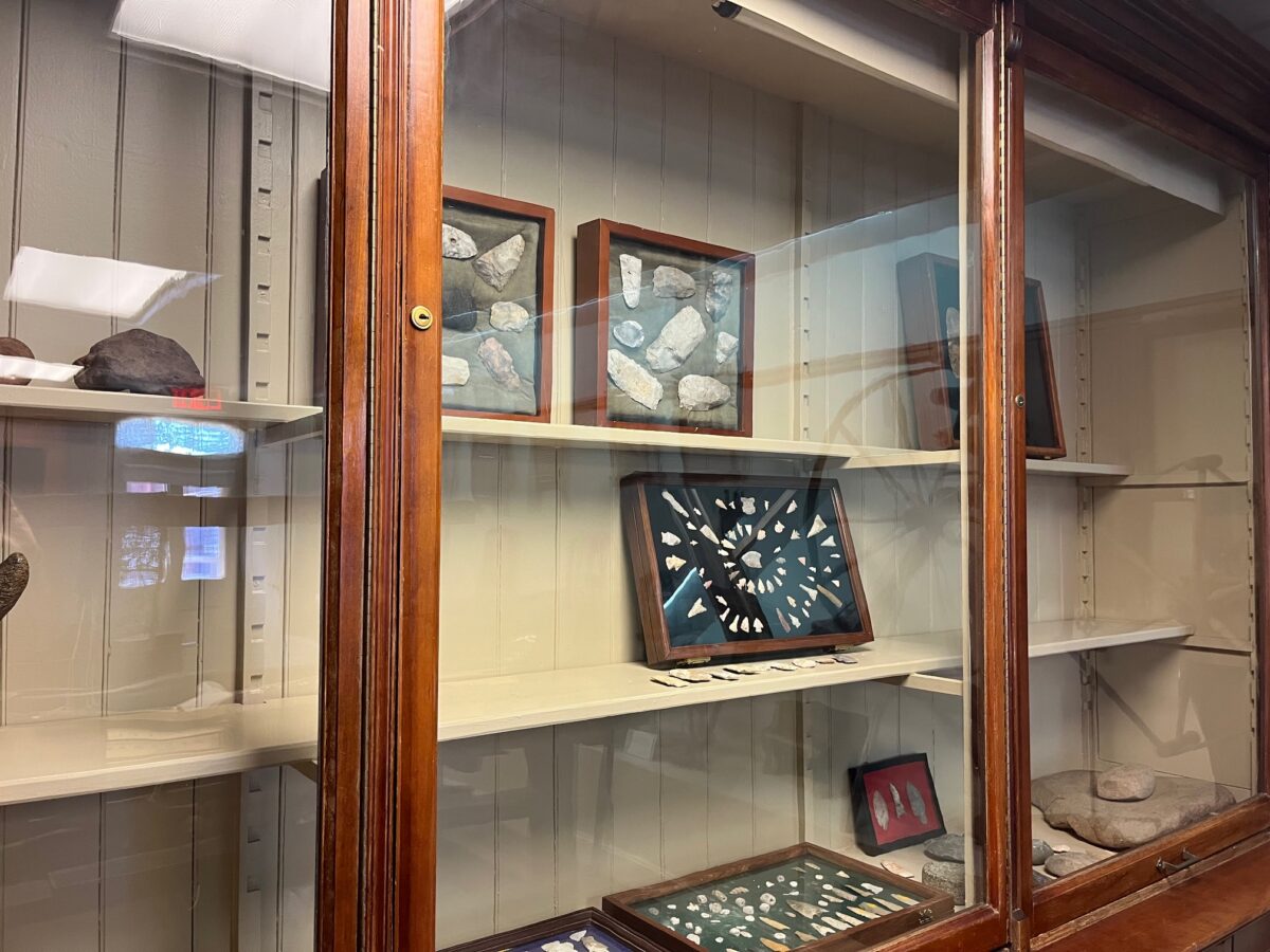 Arrowheads from Missouri behind display glass.