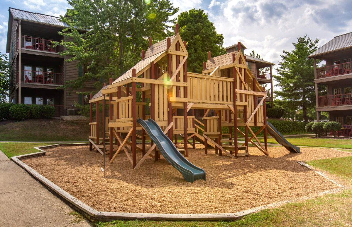 An outdoor wooden playset with a slide and other activities.