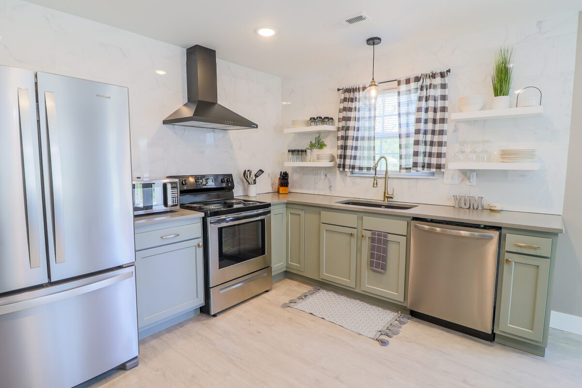 A furnished kitchen with light color palate and a window