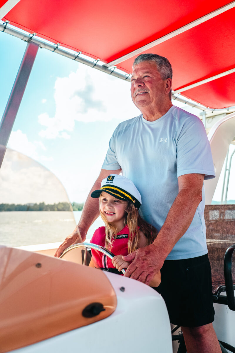 A man and child steering a boat.