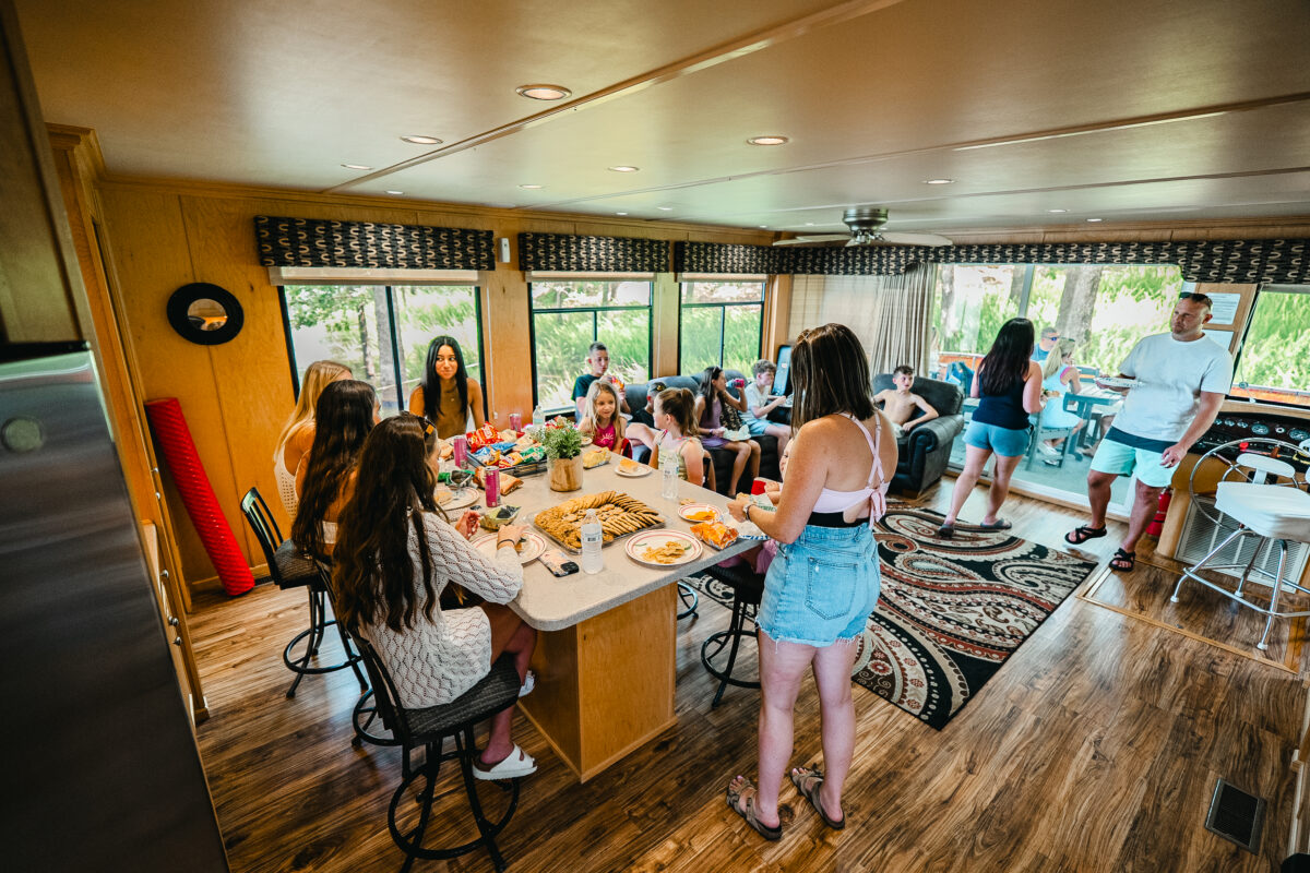 People gather around a table on a houseboat.