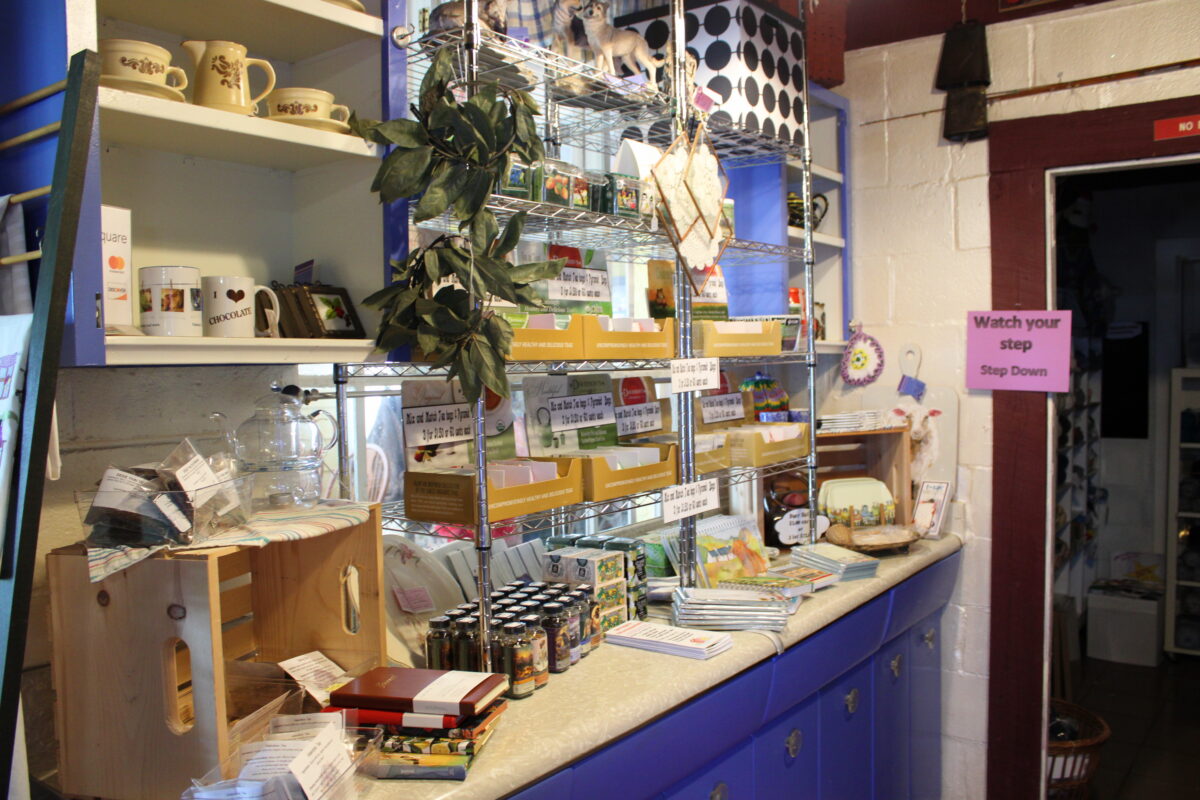 A shelf packed with items like notebooks and mugs.