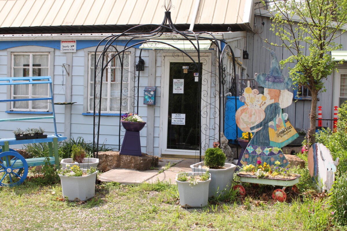 The exterior of a building with garden ornaments in the yard.