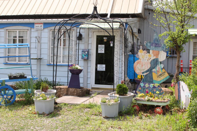 The exterior of a building with garden ornaments in the yard.