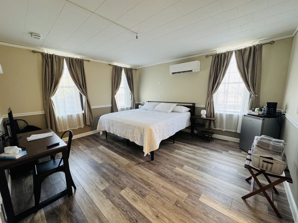 A bed in a bedroom, with several windows looking out.